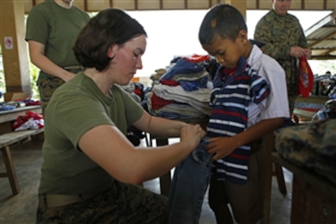 U.S. Marine Corps Lance Cpl. Erica R. Steele, a field wireman with 3rd Marine Logistics Group, fits a student with donated clothes during exercise Cobra Gold 2011 at Ban Muang Rae School, in Rayong province, Thailand, on Feb. 7, 2011.  Cobra Gold is a regularly-scheduled joint/combined exercise designed to ensure regional peace and strengthen the ability of the Royal Thai Armed Forces to defend Thailand or respond to regional contingencies.  