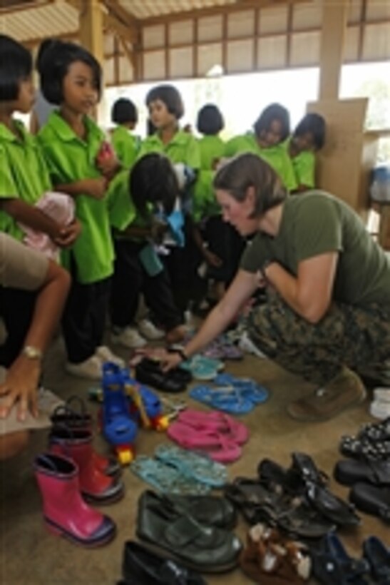 U.S. Marine Corps 1st Lt. Johanna Ciezczak, with 3rd Marine Logistics Group, fits a student with donated shoes during exercise Cobra Gold 2011 at Ban Muang Rae School in Rayong province, Thailand, on Feb. 7, 2011.  The clothing and school supplies were donated by U.S. service members and their families stationed in Okinawa, Japan, as part of a community relations program.  Cobra Gold is a regularly scheduled joint/combined exercise designed to ensure regional peace and strengthen the ability of the Royal Thai Armed Forces to defend Thailand or respond to regional contingencies.  