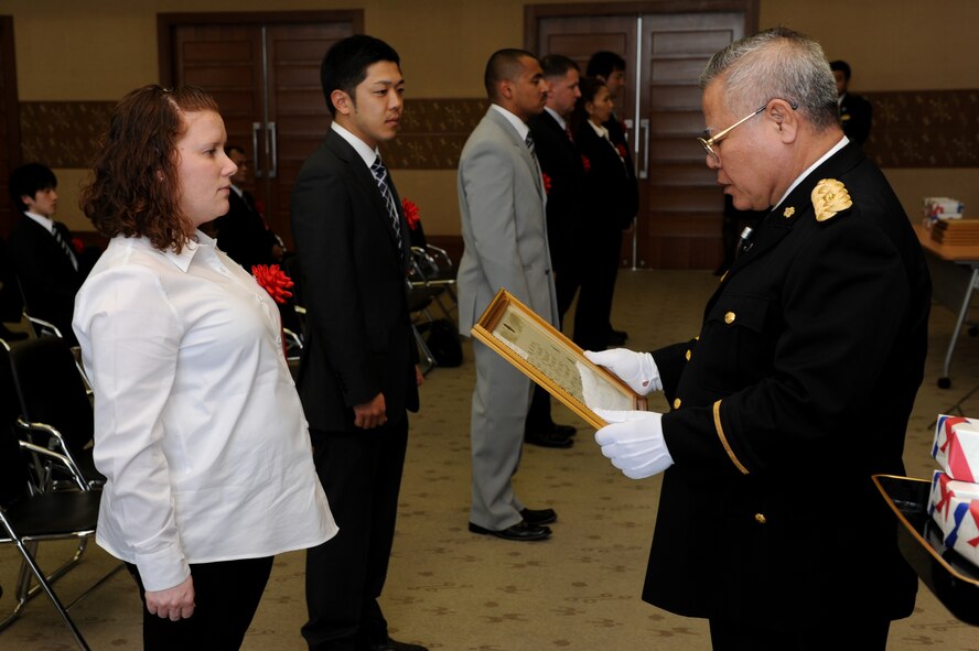 Ms. Shannon Williams, non-commissioned officer of investigations from the 18th Security Forces Squadron, Kadena Air Base, accepts a letter of appreciation from Mr. Akira Namihira, Senior Police Superintendent, Director of Community Safety Department, at the Okinawa Prefectural Police Headquarters in Naha, Okinawa, Feb. 10.The crime prevention program was established by the Juvenile Section of the Okinawa Prefecture Police along with the collaboration and support of the 18th SFS. Working together, 18th SFS and OPP have provided crime prevention classes to more than 500 students with the goal of informing and educating school-aged children about crime prevention and crime standards both on and off base. As a result, the crime rate involving juvenile, SOFA-status personnel has gone down both on and off base.  (U.S. Air Force Photo/Junko Kinjo) 