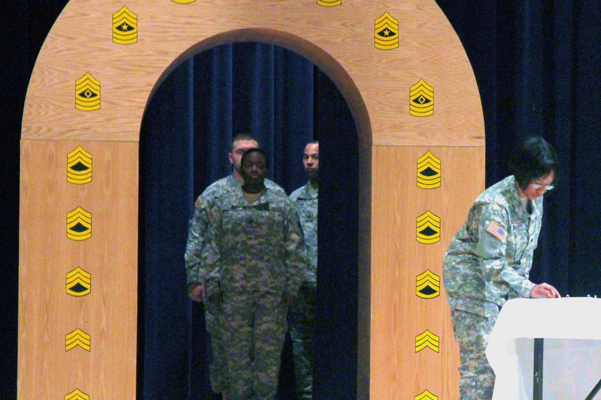 Army Sgt. Camilia Hall awaits her turn to pass through the NCO arch, marking her transition from Soldier to leader, during the 3rd MEB NCO Induction Ceremony
at the JBER Post Theater. (U.S. Army photo/SSgt. Jason Epperson)
