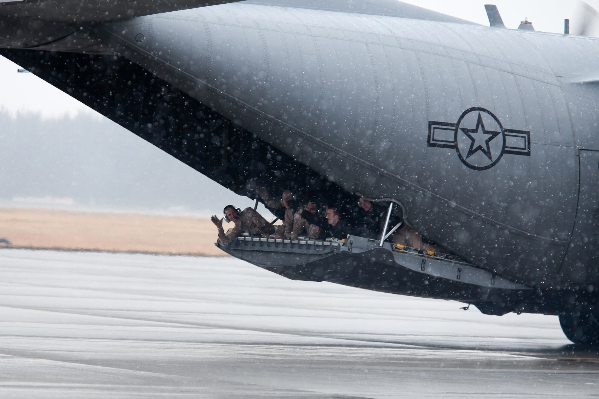 YOKOTA AIR BASE, Japan -- Members from the 36th Airlift Squadron wave farewell from the rear hatch of a C-130 Hercules here Feb. 9. Personnel from the 36th AS, 374th Operations Support Squadron and 374th Logistics Readiness Squadron deployed to Southwest Asia. (U.S. Air Force photo/Osakabe Yasuo)