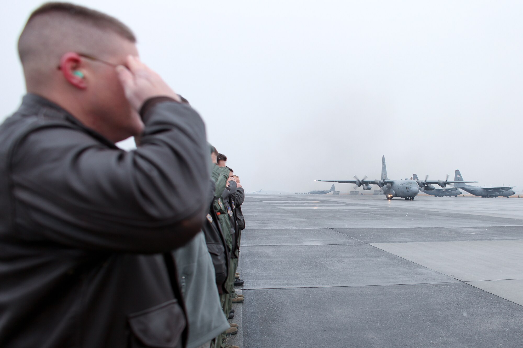 YOKOTA AIR BASE, Japan -- Leadership from the 374th Airlift Wing salute a C-130 Hercules carrying personnel from the 36th Airlift Squadron, 374th Operation Support Squadron and 374th Logistics Readiness Squadron who are heading out on a deployment to Southwest Asia Feb. 9. (U.S. Air Force photo/Osakabe Yasuo) 