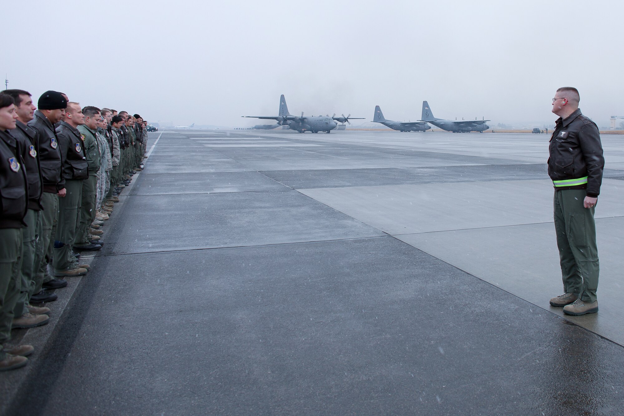 YOKOTA AIR BASE, Japan -- Lt. Col. Timothy Rapp (right), 36th Airlift Squadron commander, along with members from the 374th Airlift Wing, prepare to salute personnel from the 36th AS, 374th Operations Support Squadron, and 374th Logistics Readiness Squadron as they depart for a deployment to Southwest Asia Feb. 9. (U.S. Air Force photo/Osakabe Yasuo)