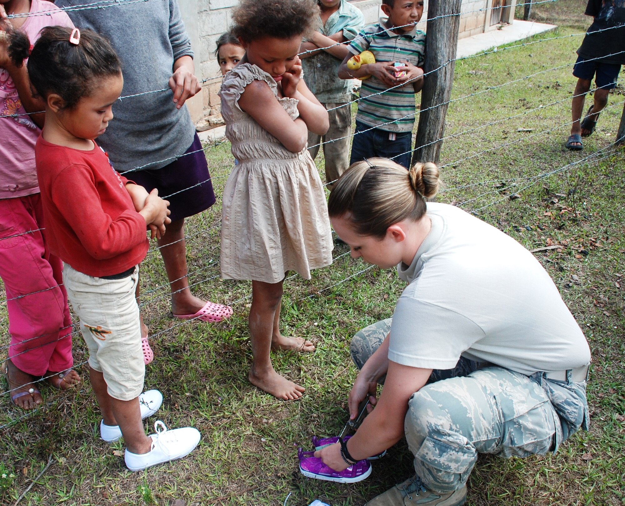 SOTO CANO AIR BASE, Honduras - Airman 1st Class Traci Blakely, Joint Task Force-Bravo Medical Element tecnician, fits a child in Montana de la Flor with a new pair of shoes Jan. 29.  Blakely served on a team of personnel from Joint Task Force-Bravo during a medical readiness training exercise there.  The shoes were donated by the American non-governmental organization Honduras Mission LeMars. (U.S. Air Force photo/Capt. John T. Stamm)