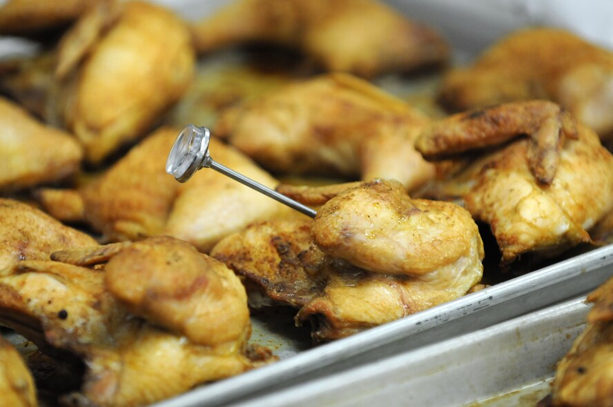 A food thermometer is used to ensure the lunch entrée of baked chicken is thoroughly and safely cooked at Chadwell Dining Facility. (U.S. Air Force photo by R.J. Oriez)