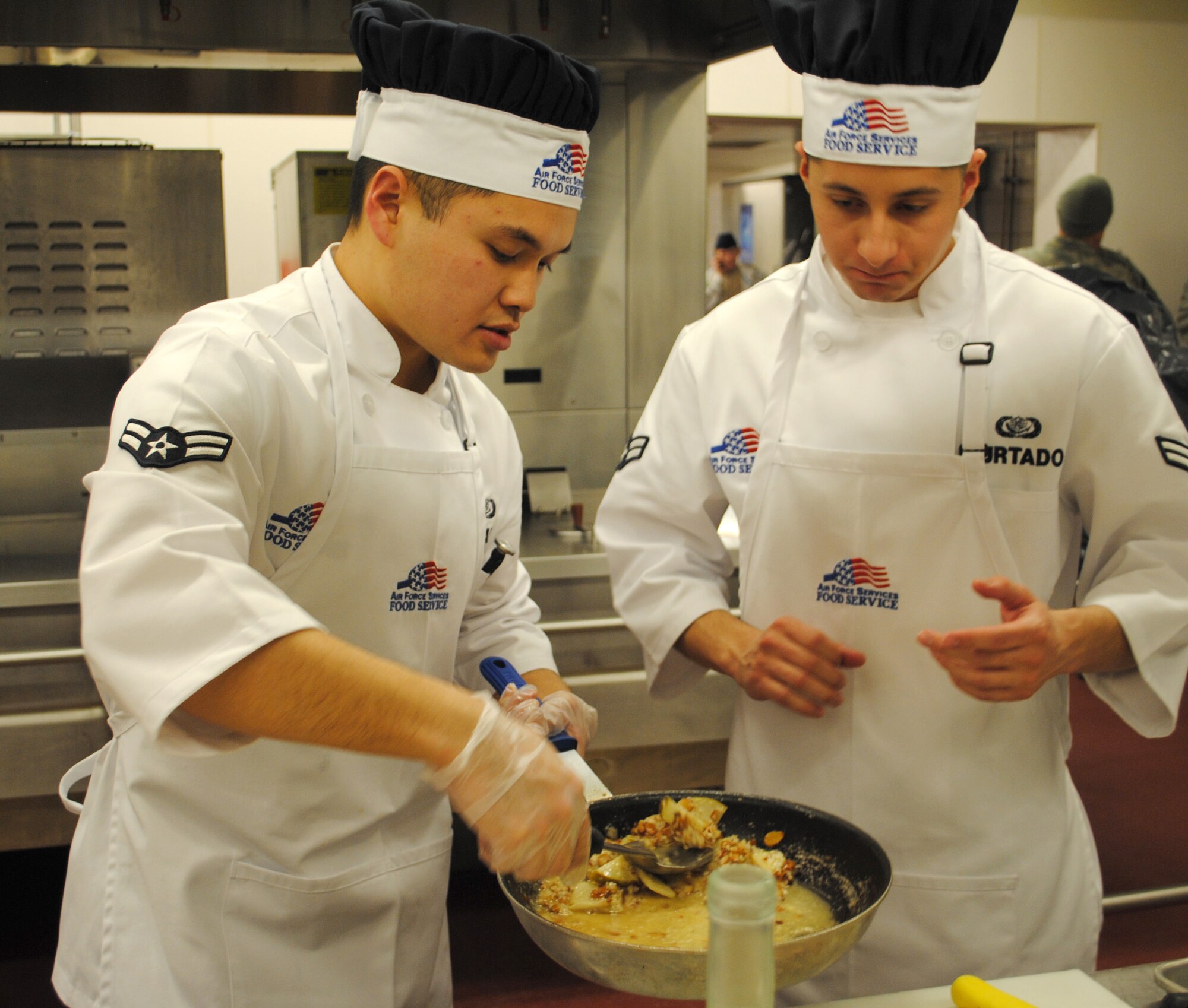 Airman 1st Class Louie Sabado, a 341st Force Support Squadron services apprentice (left), and Airman 1st Class Edward Hurtado, a 341st FSS food technician prepare their dish for presentation to the judges during the Warrior Chef competition.  FSS was competing agains the 10th, 12th and 490th Missile Squadrons for a chance to be named this quarters Warrior Chefs. (U.S. Air Force photo/Airman Cortney Hansen)