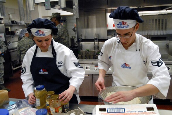 Staff Sgt. Chloe Martin, and Senior Airman Rodolfo Isuhuaylas, both 10th Missile Squadron missile chefs, work together preparing a dish to be judged at the first 2011 Warrior Chef competition.  After an hour and a half in the kitchen, their meal was ready to compete against three other team's dishes. (U.S. Air Force photo/Staff Sgt. Dillon White)