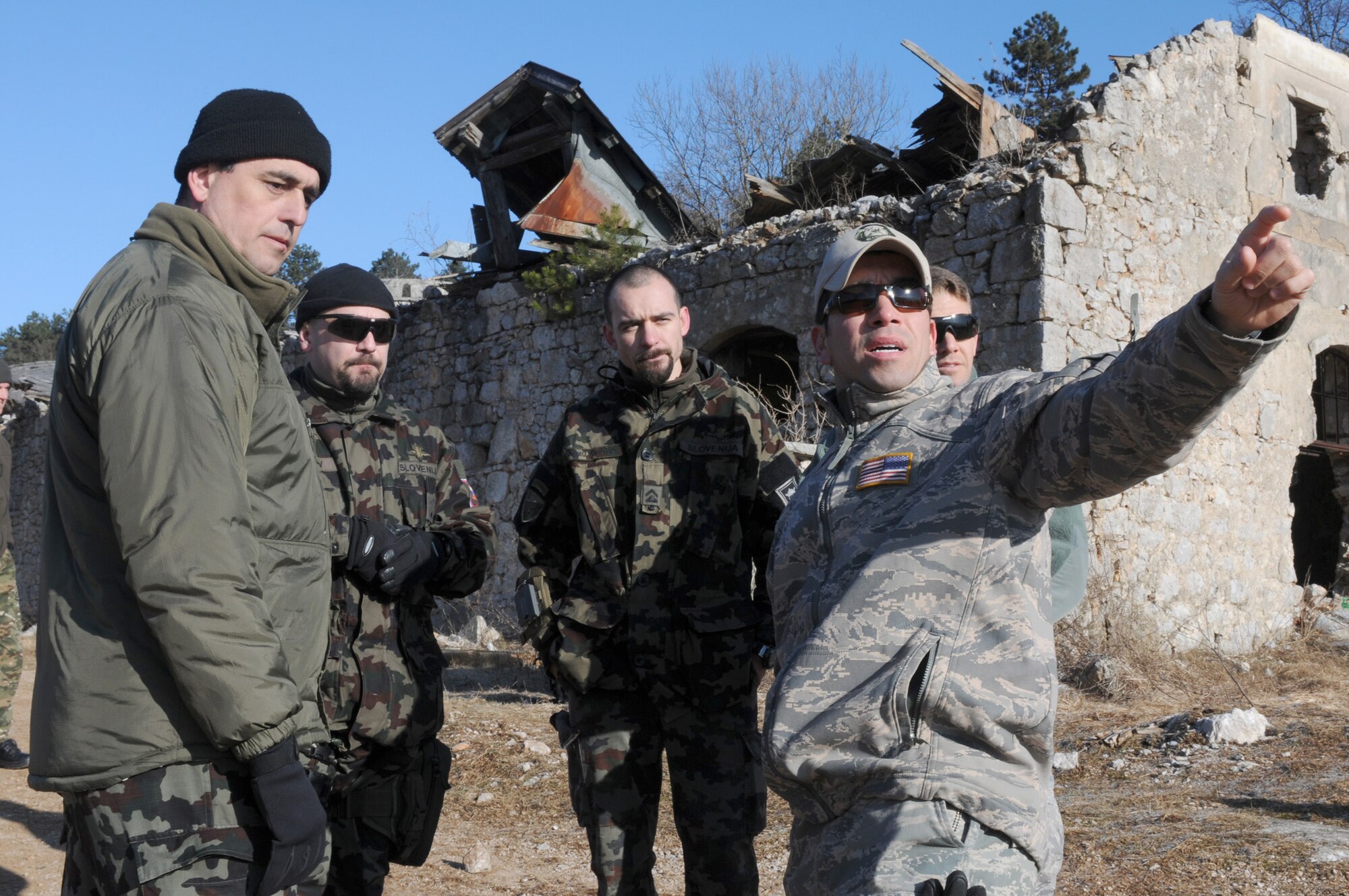 Tech. Sgt. Eduardo Ramos explains the sequence of events to three Slovenian army joint terminal attack controllers during a NATO coalition combat capability training exercise at Pocek Range Feb. 3, 2011, in Postojna, Slovenia. The exercise consisted of close-air-support training between Airmen from Aviano Air Base, Italy, and Slovenian army JTACs and tactical air control party operators, as well as Slovenian PC-9M aircrews. Sergeant Ramos is a  8th Air Support Operations Squadron JTAC. (U.S. Air Force photo/Staff Sgt. Nadine Y. Barclay)