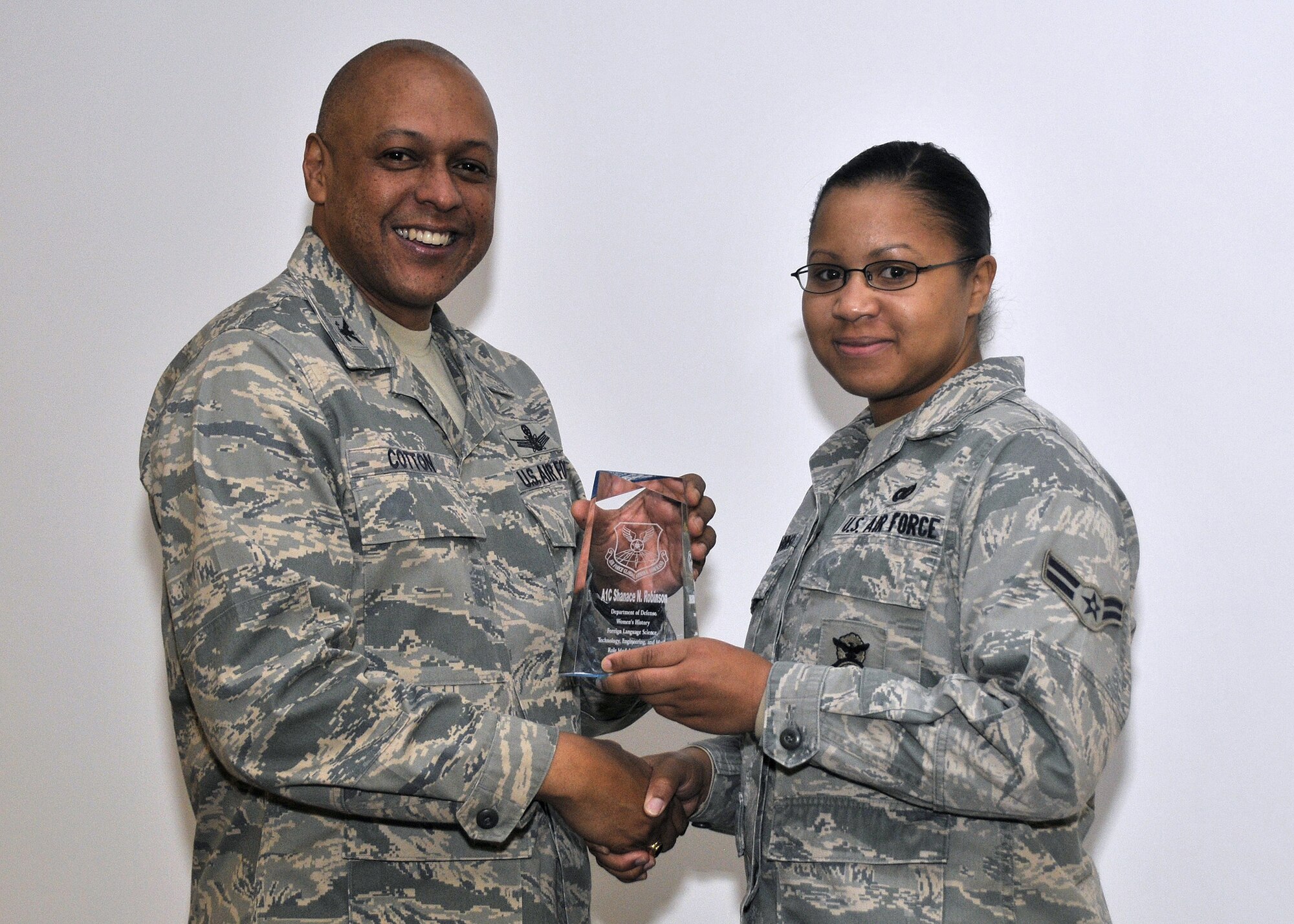 Brig. Gen. (Sel) Anthony Cotton, 341st Missile Wing commander, pauses for a photo with Airman 1st Class Shanace Robinson after presenting her the Women's History Month Foreign Language and Science, Technology, Engineering and Math Role Model Award at the major command level. (U.S. Air Force photo/John Turner) 