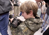 Brady Rusk, 12, hugs Eli, a bomb-sniffing military working dog, during a retirement and adoption ceremony at the Military Working Dog School Feb. 3. The Labrador retriever was assigned to Brady's older brother, Marine Pfc. Colton Rusk, who was killed Dec. 6 in Afghanistan by Taliban sniper fire. (U.S. Air Force photo/Robbin Cresswell)