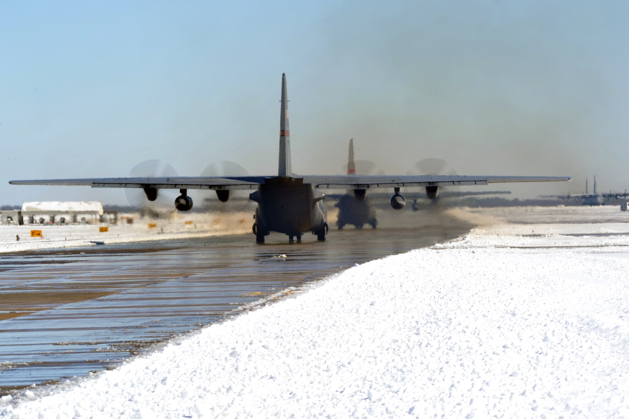 A pair of C-130 Hercules taxi down the flightline Feb. 10, 2011, at Little Rock Air Force Base, Ark. Due to the efforts of numerous Team Little Rock members, the flightline was clear for continued base operations. (U.S Air Force photo by Staff Sgt. Chris Willis)