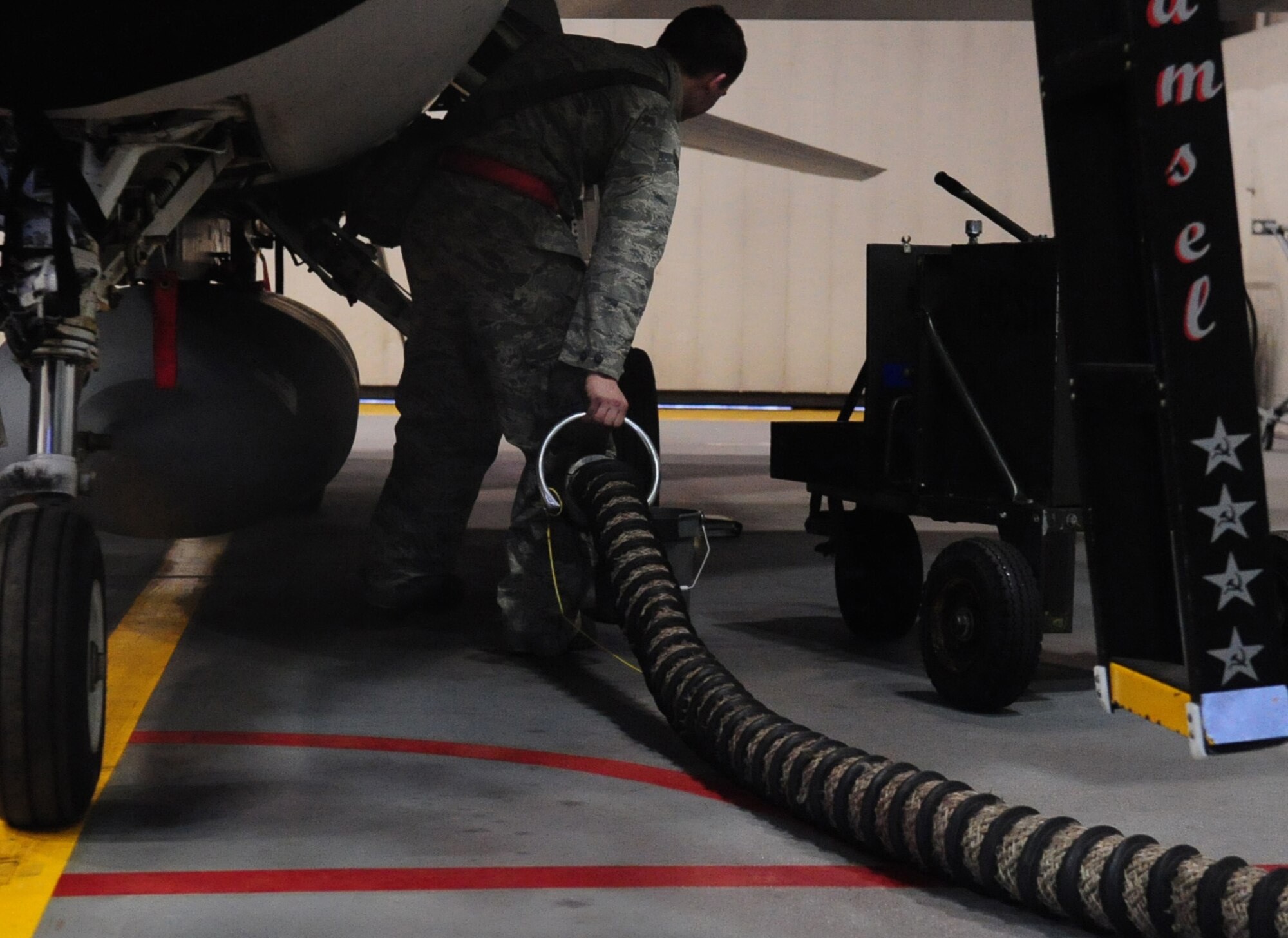 Airman 1st Class Matthew Just drags a cooling hose under an F-16 Fighting Falcon Feb. 8, 2011 Eielson Air Force Base, Alaska. Airman Just prepares the F-16 to undergo several safety inspections and mechanical functions checks to its radar. Airman Just is an avionics specialist assigned to the 354th Aircraft Maintenance Squadron. (U.S. Air Force photo/Airman 1st Class Laura Goodgame) 