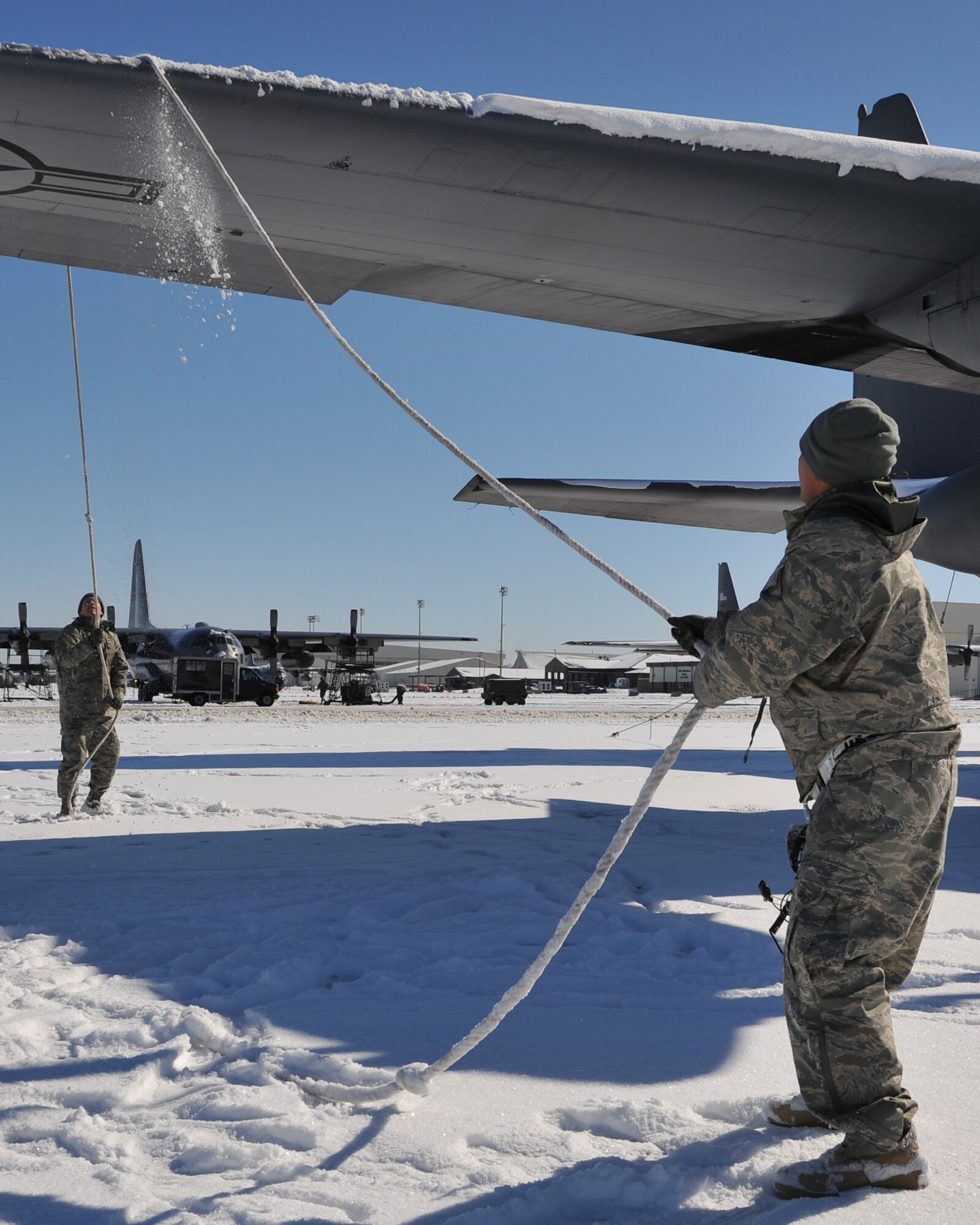 Staff Sgt. Richard Vallejo (front), a 19th Aircraft Maintenance Squadron electrical environmental systems technician, and Airman Ben Lepke, a 19th Equipment Maintenance Squadron metals technician, remove the snow off of a C-130 wing Feb. 10, 2011, at Little Rock Air Force Base, Ark. The snow must be removed so the C-130 remains ready for flight. (U.S. Air Force photo by Airman 1st Class Rusty Frank)