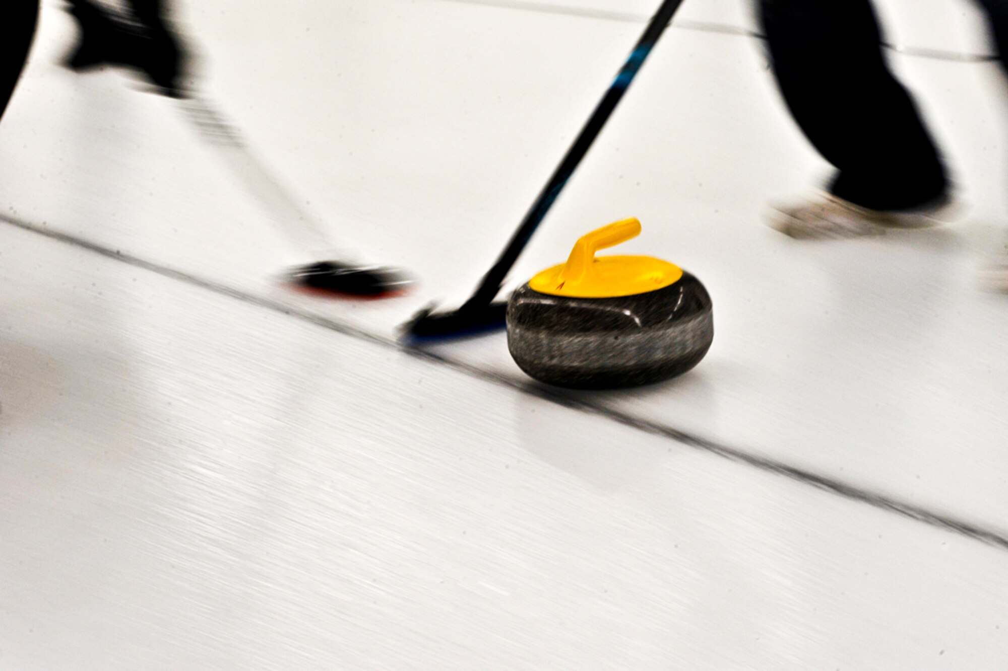 ANCHORAGE, Alaska ? Members of the Air National Guard Curling team sweep to help move their ?stone? farther down the ice. The Canadian team went to the finals of the Top Rock tournament in Anchorage to lose to the Air National Guard team. (U.S. Air Force photo/ Airman 1st Class Jack Sanders)