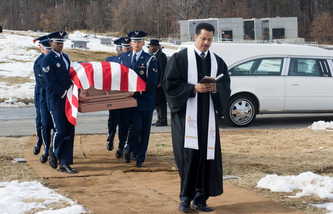 Reverend Mark Vincent, pastor, Ebenezer United Methodist Church, Lanham, Md., leads the funeral procession, quoting a verse from the Bible as Team Andrews ceremonial guardsmen follow, carrying the casket of the late Capt. Charles Flowers at the Harmony Memorial Cemetery in Hyattsville, Md., Feb. 4.  (U.S. Air Force photo/Bobby Jones)