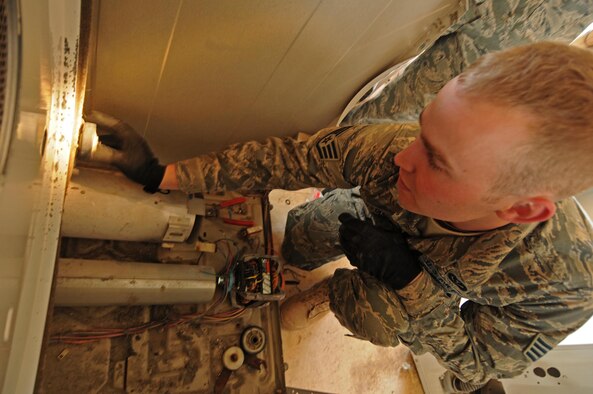 Staff Sgt. Ryan Constance replaces a dryer wheel on a dryer here. Sergeant Constance is learning the ins and outs of washer and dryer maintenance from staff sergeants Tim Holt and Gregory Wilcoxen, both Sears home repairmen and Air Force Guard members. Sergeant Holt and Constance are water and fuels journeymen with the 386th Expeditionary Civil Engineer Squadron and Sergeant Wilcoxen is a heating, ventilation and air conditioning journeyman also with the 386th ECES. (U.S. Air Force Photo by Staff Sgt. Patrice Clarke)