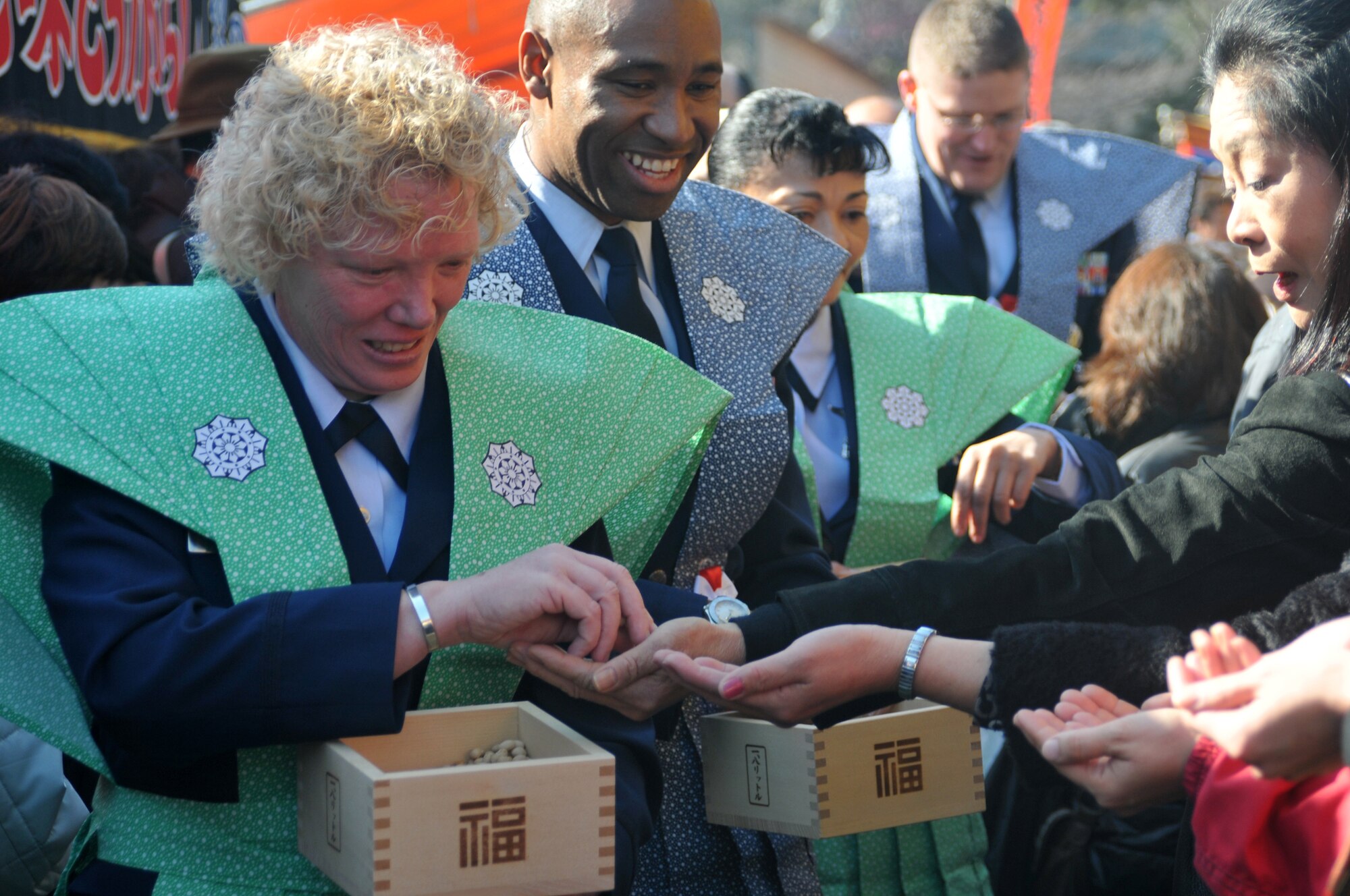 HINO CITY, Japan -- Airmen from Yokota Air Base, Japan, hand out roasted soy beans to Hino City residents at the Bean Throwing Ceremony here Feb. 3. The ceremony is an annual event held to celebrate the start of a new year with the prospect of good fortune. (U.S. Air Force photo/Airman 1st Class Krystal M. Garrett) 