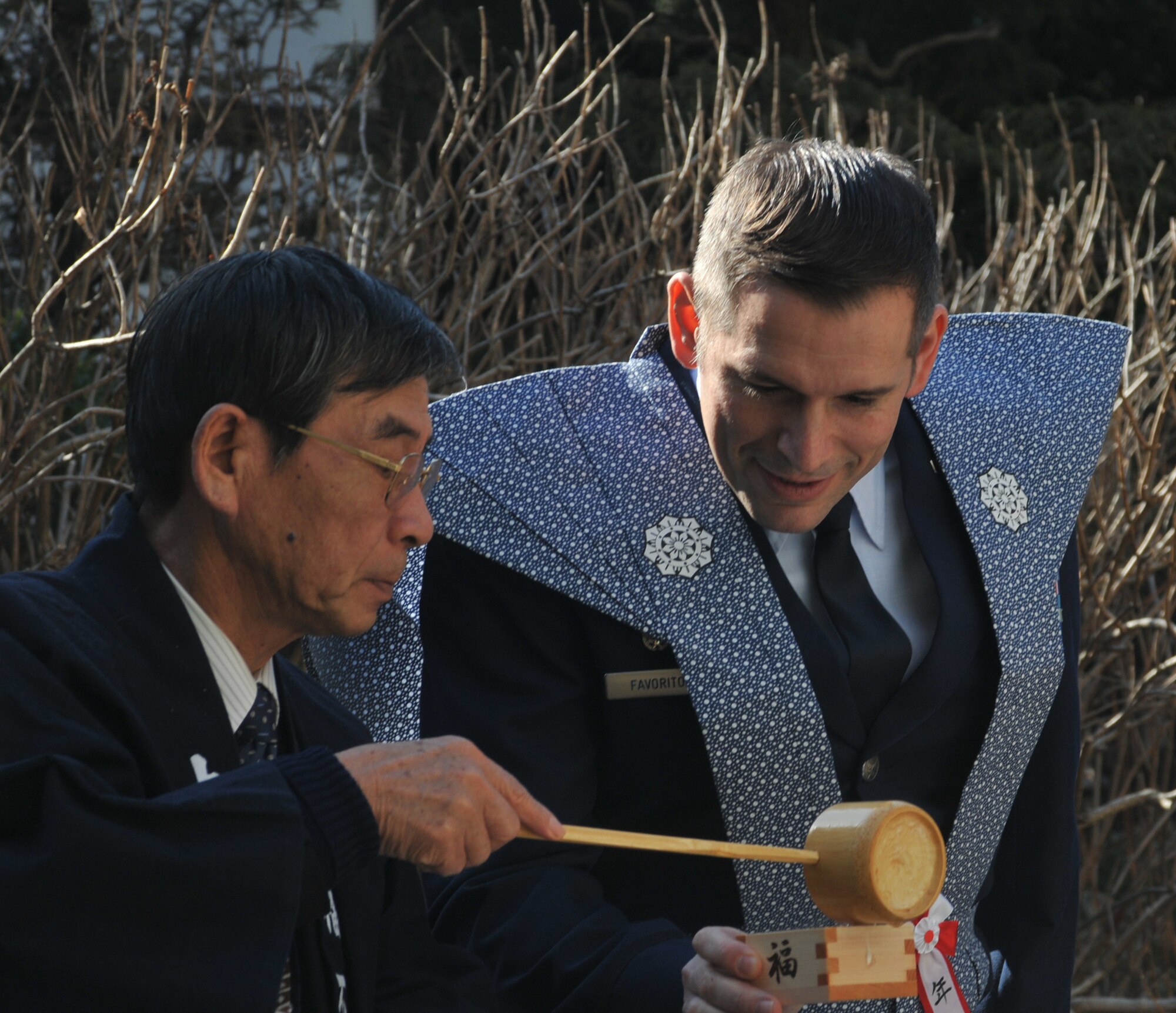 HINO CITY, Japan -- A Hino City resident pours Lt. Col. Rocky Favorito, 374th Communications Squadron commander, Yokota Air Base, Japan, sake during the Bean Throwing Ceremony held at Takahata Fudo Temple here Feb. 3. During the ceremony roasted soy beans are thrown into the crowd. It is traditionally believed that if an individual eats the number of beans equal to their age they will have a happy and healthy life. (U.S. Air Force photo/Airman 1st Class Krystal M. Garrett)  

