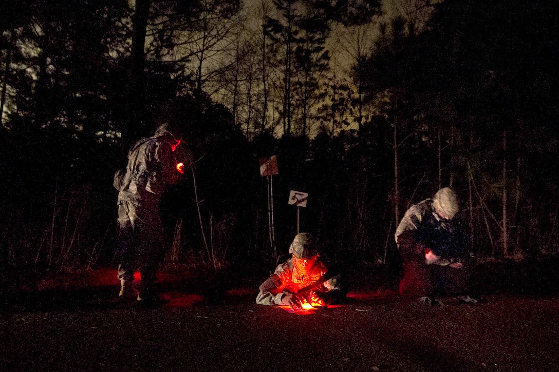 U.S. Army paratroopers plot waypoints on a map during the night land ...