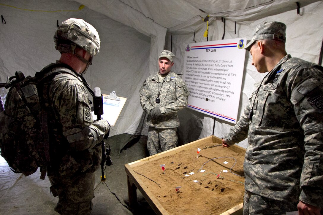 U.S. Staff Sgt. Lucas Decker, center, and Staff Sgt. Forsti Miller, right, brief a candidate on an entry-control point scenario on Fort Bragg in N.C., Feb. 1, 2011. The candidate must complete eight of 10 tasks correctly.