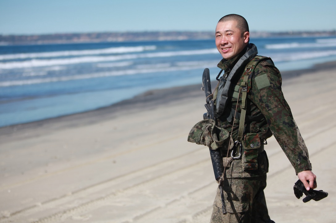 Master Sgt. Ueda Ryuichi, a scout swimmer squad leader with the Japanese Ground Self Defense Force, Western Army Infantry Regiment prepares to simulate securing a beach during combat rubber raiding craft training here Feb. 10. The soldiers are participating in Exercise Iron Fist, a bilateral training exercise conducted with the 11th Marine Expeditionary Unit to strengthen the bond between the U.S. and Japanese militaries.
