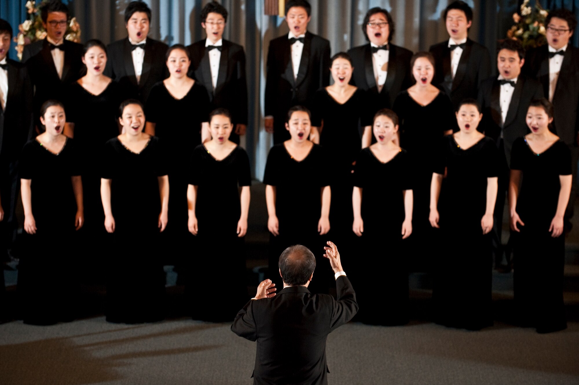 NELLIS AIR FORCE BASE, Nev. --  Chai Hoon-Cha, Korean Students Glee Club conductor, conducts the glee club choir during a performance at the base chapel Feb. 10. The Korean Students Glee Club is on tour throughout the United States and Canada until Feb. 23, 2011. The Glee Club was established in 1966 and is composed of college students studying music in various universities in the Seoul metropolitan area. (U.S. Air Force photo by Tech. Sgt. Michael R. Holzworth)
