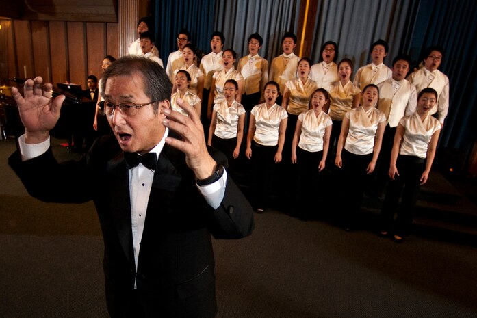 NELLIS AIR FORCE BASE, Nev. --  Chai Hoon-Cha, Korean Students Glee Club conductor, turns toward the audience while the glee club choir performs in the background at the base chapel Feb. 10. The Korean Students Glee Club is on tour throughout the United States and Canada until Feb. 23, 2011. The Glee Club was established in 1966 and is composed of college students studying music in various universities in the Seoul metropolitan area. (U.S. Air Force photo by Tech. Sgt. Michael R. Holzworth)