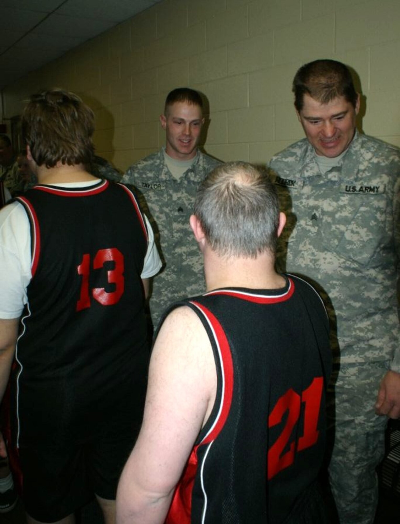 Sgt. Michael Taylor (left) and Sgt. Richard Rodrick (right), of the 35th Infantry Division in St. Joseph, congratulates athletes with the Special Olympics as they prepare to take the court. Missouri National Guardsmen, along with other uniformed law enforcement and public safety officers, attended the opening ceremonies for a recent basketball tournament at Missouri Western State University. (Photo by Jennifer Archdekin)
