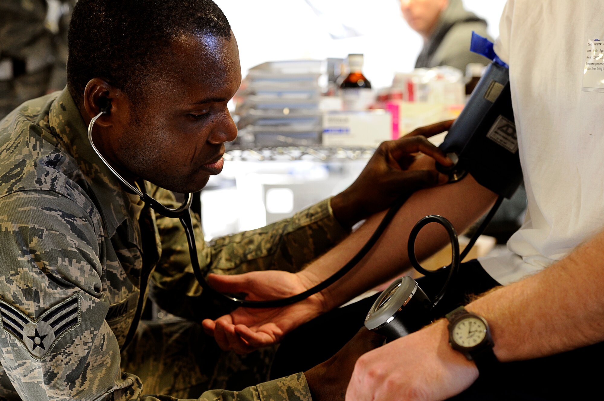 A service member from the 60th Medical Group checks vitals of a patient during a field test of the "hospital in a box." The 615th Contingency Response Wing and 60th MDG paired up Feb. 9 during a disaster simulated exercise. U.S. Air Force photo Tch. Sgt. Dennis Henry Jr