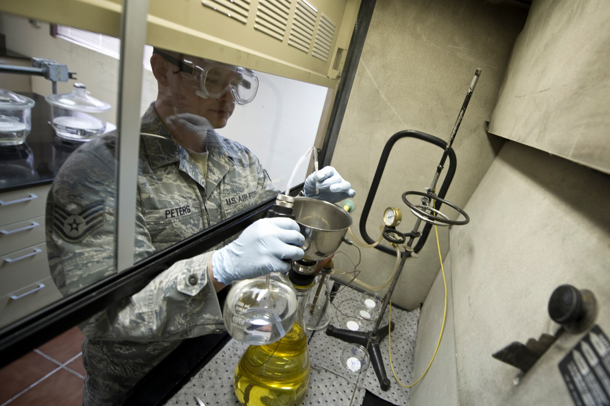 HOLLOMAN AIR FORCE BASE, N.M. -- Staff Sgt. Anthony Peters, 49th Fuels Management Flight, samples JP-8 jet fuel at the Holloman Laboratory, Feb. 9, 2011. Sergeant Peters is testing a sample through the bottle method, which is used to ensure the fuel is clean and safe for use in high-performance aircraft. (U.S. Air Force photo by Airman 1st Class Joshua Turner/Released)