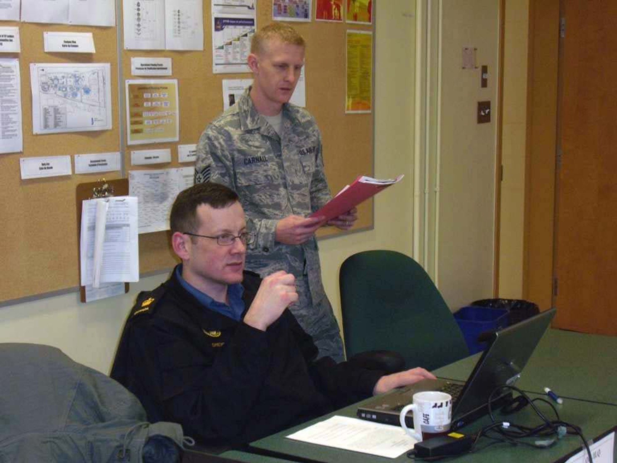 Tech. Sgt. Robert Carnall, 702nd Computer Support Squadron System Administrator, confers with a Canadian Navy petty officer on a project at the Canadian Intermediate Leadership program at the Canadian Forces College, Noncommissioned Member Professional Development Center, St. Jean Sur Richelieu in Quebec Canada. (Photo by Chief Petty Officer 2 Frank Lauzier)
