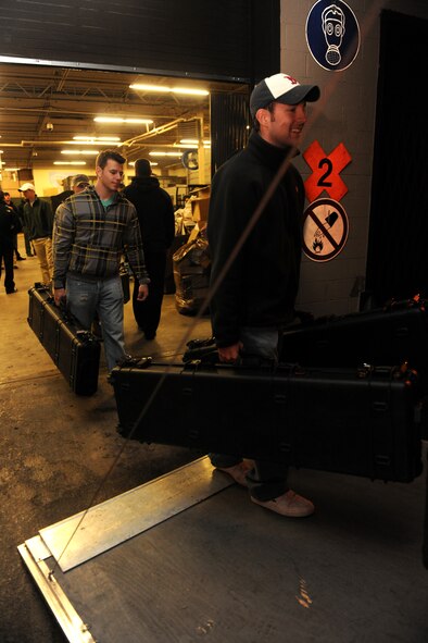 MOODY AIR FORCE BASE, Ga. -- Staff Sgts. Nicholas Haskell and Tyler Smitka, 823rd Base Defense Squadron fire team leaders, carry Pelican cases onto a waiting trailer before leaving to Fort Bragg, N.C., to participate in a joint forces exercise Feb. 10. Members of the 823rd BDS will integrate into a U.S. Army Airborne unit and conduct an airfield seizure during the exercise. (U.S. Air Force photo/Airman 1st Class Benjamin Wiseman)(RELEASED)