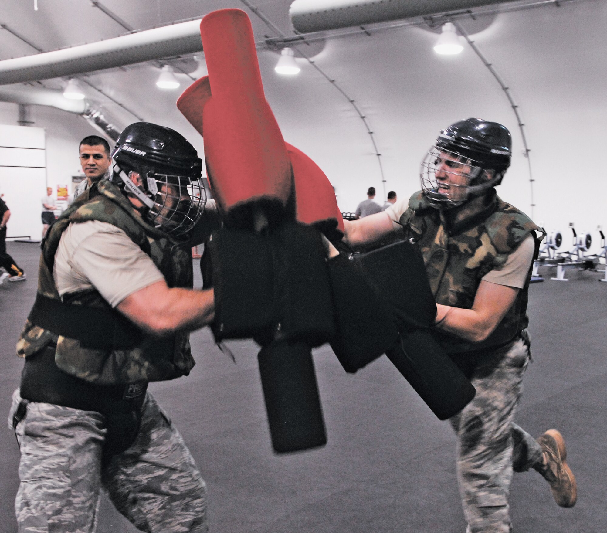 Tech. Sgt. George Oakley, 56th Component Maintenance Squadron, left, and Airman 1st Class Aaron Peacock, 56th Component Maintenance Squadron, spar against each other using pugil sticks on February 8th during the course held in the Combat PT Center at Luke Air Force Base, Arizona.  (U.S. Air Force photo/Airman David Owsianka)