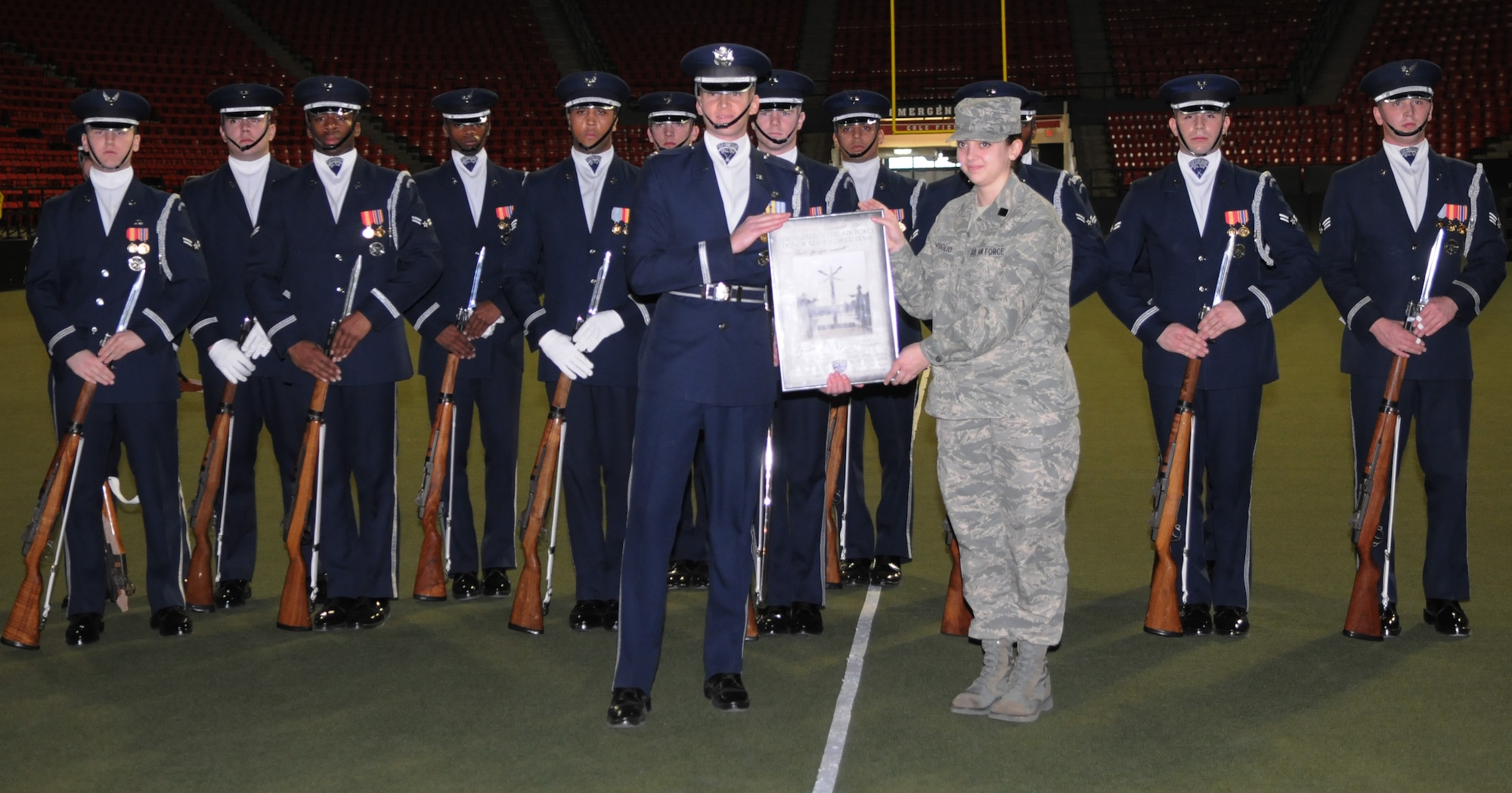 Capt. Chad Frey, The U.S. Air Force Honor Guard drill team commander, presents an autographed photo to Cadet Col. Mary Depuglio, the cadet wing commander of the University of Maryland University Air Force ROTC, Feb. 10 at the UMU campus in College Park, Md. Cadet Colonel Depuglio was one of the key organizers of the performance for her fellow cadets. (U.S. Air Force photo by Senior Airman Christopher Ruano)