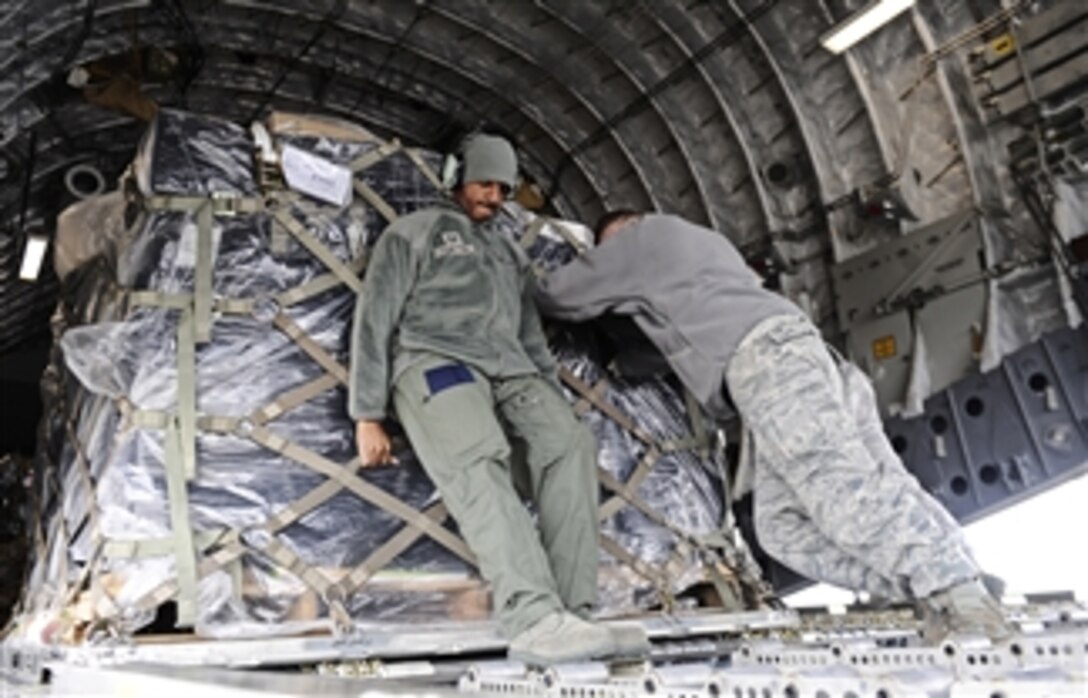 Tech Sgt. Matthew Hamilton helps members of the 375th Logistics Readiness Squadron push a 500-pound pallet onto a C-17 Globemaster III at Scott Air Force Base, Ill.  Hamilton is a loadmaster assigned to the 452nd Air Mobility Wing.  
