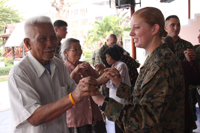Lance Cpl. Skylar Harris, an air control electronics operator for Marine Air Control Squadron 4, dances with an elderly man at the Thamrapakorn Home for the Aged Feb. 12 during a community relations project for Cobra Gold 2011.