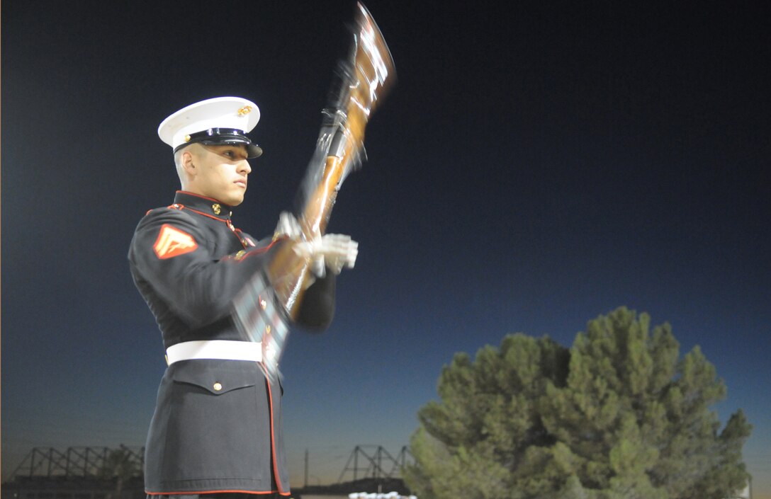 Cpl. Oscar Franquez, the Silent Drill Platoon's guide and rifle inspector, practices the single inspection sequence Feb. 12, 2011, at the Marine Corps Air Station in Yuma, Ariz. The Silent Drill Platoon from Marine Barracks Washington, D.C., also known as 8th & I, comes to the station annually to complete Silent Drill School and to prepare for the Marine Corps Battle Colors Detachment tour. During the show, Franquez plays the role of rifle inspector in the inspection sequence, demonstrating elaborate rifle spins and tosses. The rifle being spun is the M-1 Garand used during World War II. "It's a great honor and privilege to be a part of the Silent Drill Platoon," said Franquez. "It is not only a chance to represent the Marine Corps, but your family and where you come from." The Battle Colors ceremony is scheduled for March 3, 2011, at 10:30 a.m. on the station parade field. Two free performances for the public are scheduled for March 3, 2011, at 7 p.m. at Kofa High School and March 4, 2011, at 7 p.m. at Arizona Western College.