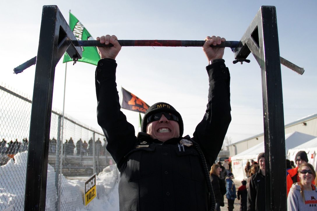 Moorhead Patrol Officer Brad Schenck knocks out his last rep while taking the Marine Corps pull-up challenge in full gear during Hockey Day Minnesota Feb. 12. Throughout the day, dozens of people visited the Marine booth to interact with Fargo recruiters and take a picture next to the Marine Corps Hummer.