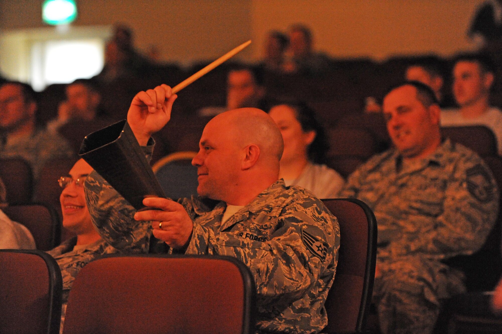 Staff Sgt. Jonathon Caruso, a vehicle operator with the 386th Expeditionary Logistics Readiness Squadron, adds a little cowbell during a Three Day Threshold concert here Feb. 9. The Boston-based band stopped at The Rock as part of their Armed Forces Entertainment tour through the Air Force Central Command Area of Responsibility. (U.S. Air Force photo by Senior Airman Cynthia Spalding)