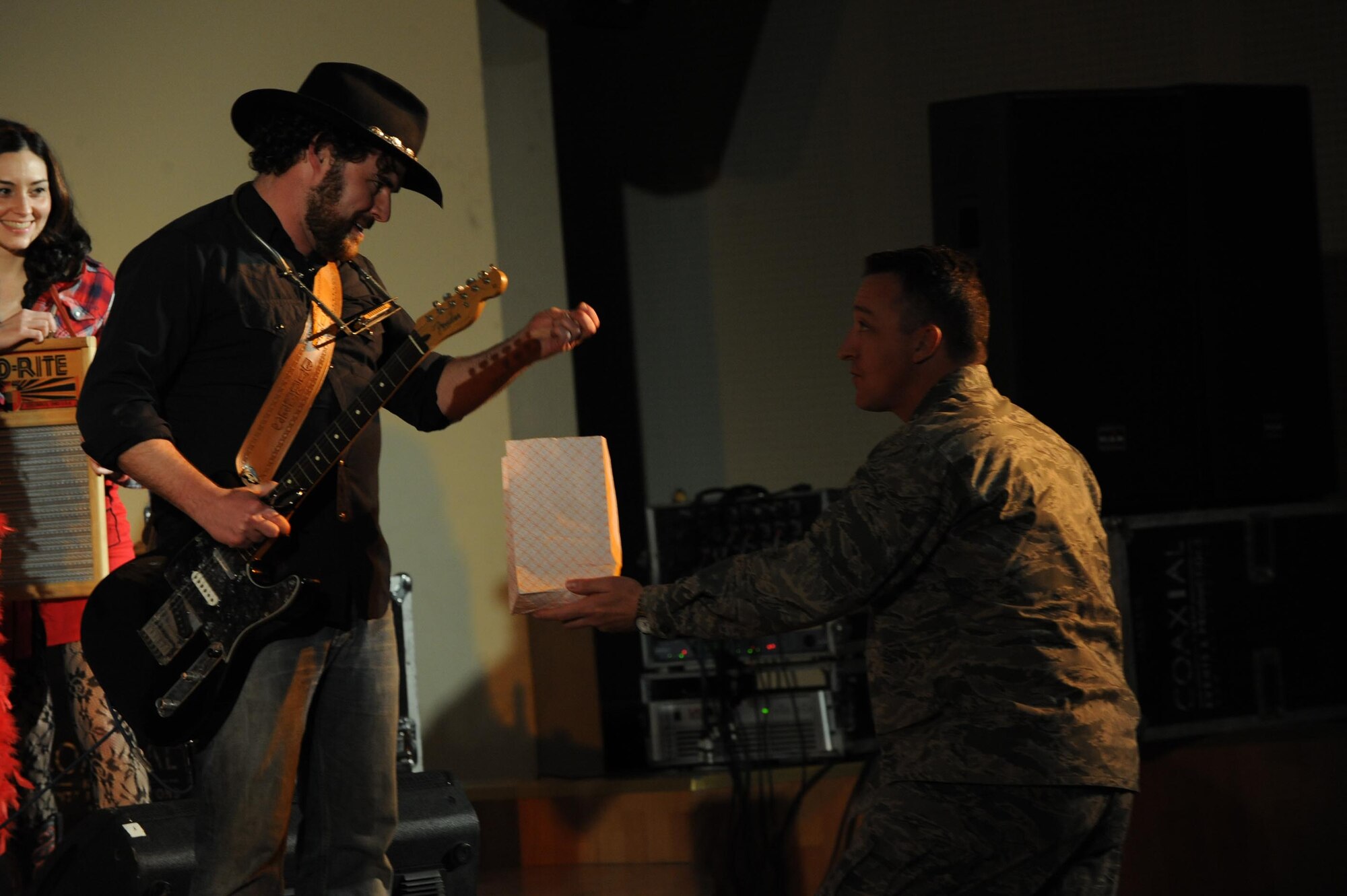 Kier Byrnes, guitarist and vocalist for Three Day Threshold, takes some popcorn from Col. Patrick Mordente, 386th Air Expeditionary Wing commander, during a concert here Feb. 9. The Boston-based band visted the 386th AEW as part of their Armed Forces Entertainment tour throughout the Air Force Central Command Area of Responsibility. (U.S. Air Force photo by Senior Airman Cynthia Spalding)