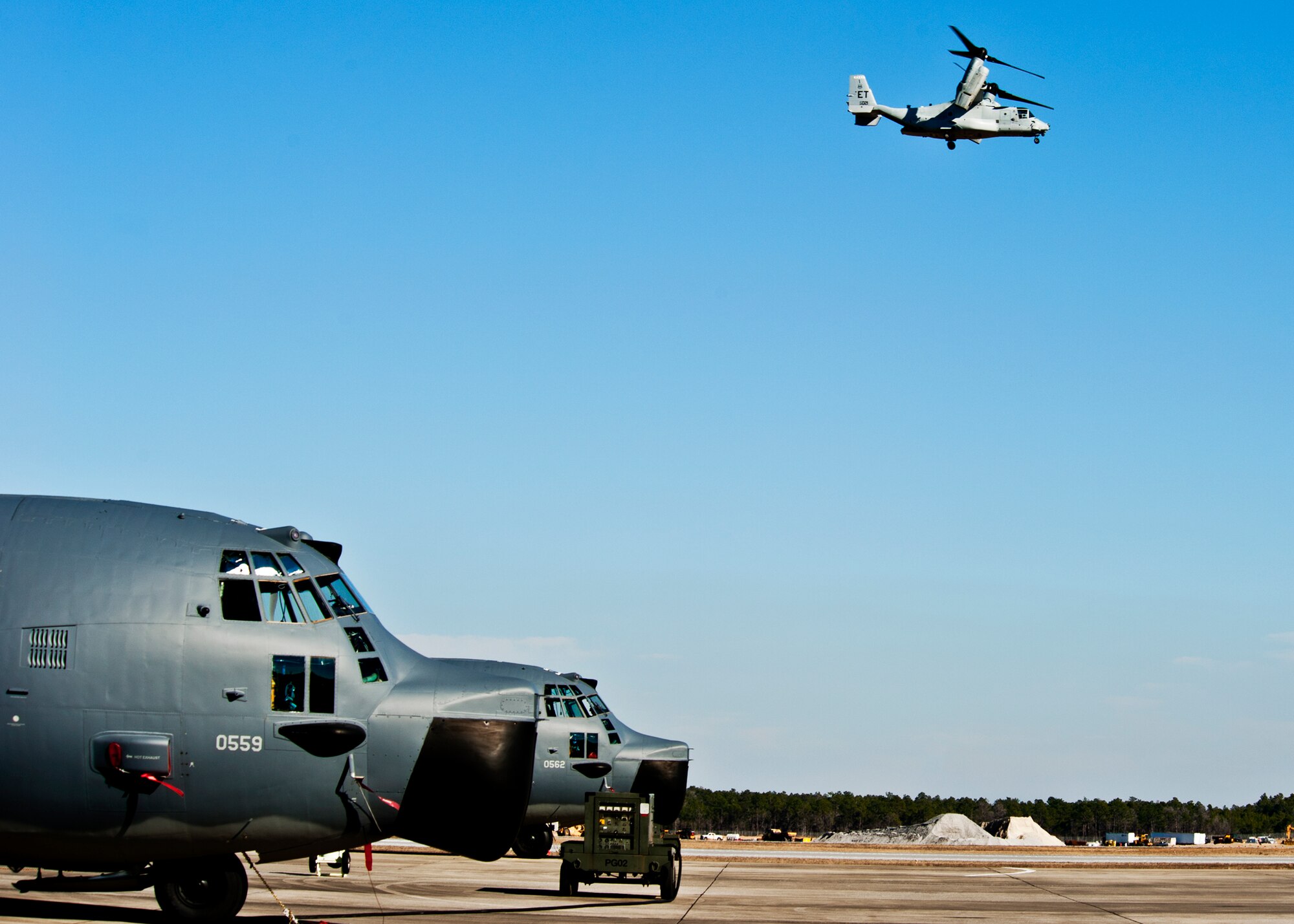 A CV-22 Osprey from the 413th Flight Test Squadron flies overhead as the 919th Special Operations Wing MC-130E Talons wait to be launched.  Duke Field’s flightline is busy again after an eight-month construction project.  (U.S. Air Force photo/Tech. Sgt. Samuel King Jr.)
