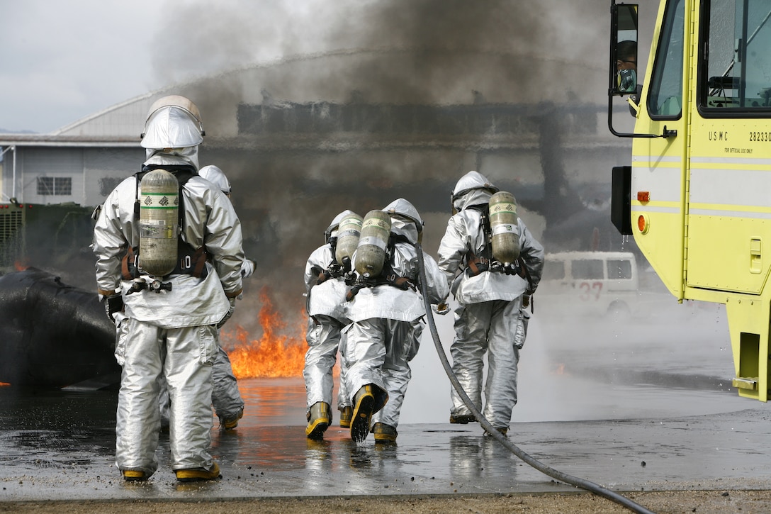 A station Aircraft Rescue and Firefighting crew demonstrates teamwork while preparing to extinguish a fire during a live fire exercise here Feb. 13. The importance of teamwork is monumental to the ARFF Marines who eat, work and sleep together. It is important to know what the other Marine is capable of.