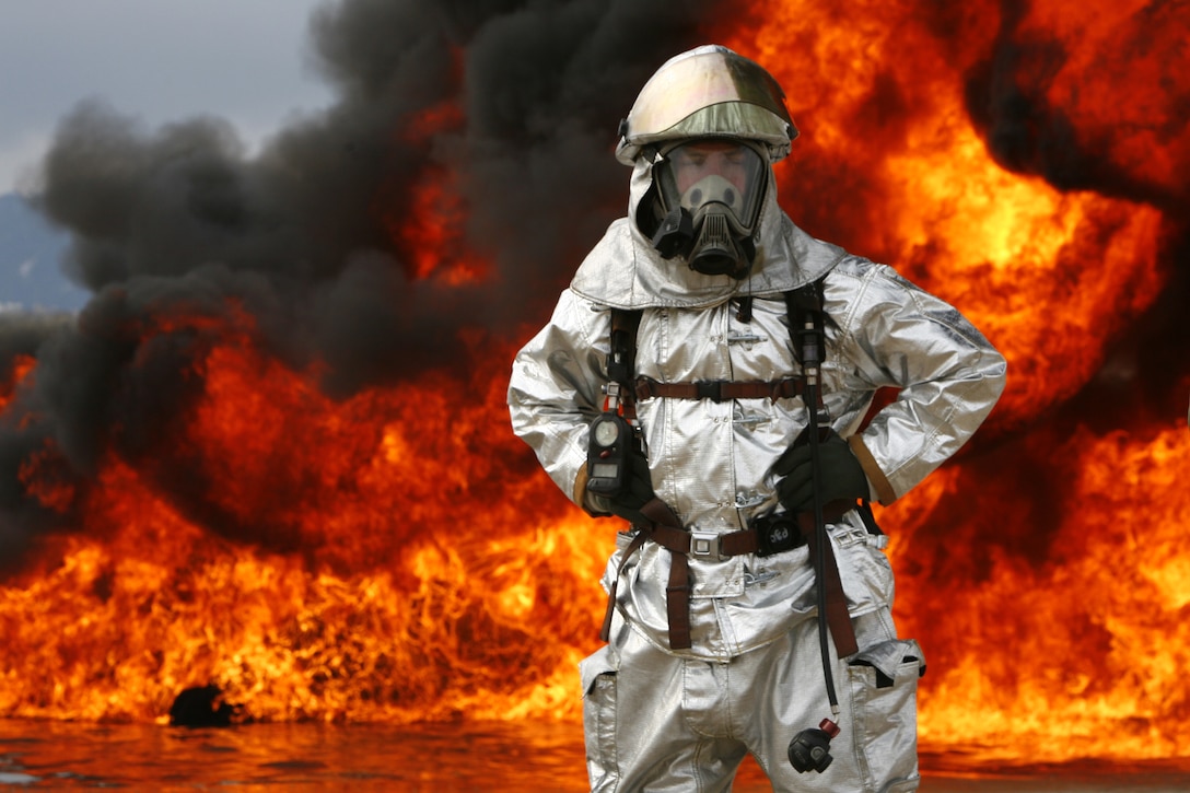 Sgt. Bruce L. Best, station Aircraft Rescue and Firefighting specialist, stands amidst the flames in his heat-reflecting, metallic silver proximity gear during a live fire training exercise here Feb. 13. The gear is different from normal structural firefighting gear because ARFF Marines are exposed to more intense heat from the fuel used in aircraft.