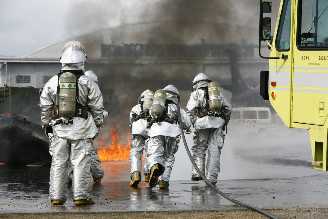 A station Aircraft Rescue and Firefighting crew demonstrates teamwork while preparing to extinguish a fire during a live fire exercise here Feb. 13. The importance of teamwork is monumental to the ARFF Marines who eat, work and sleep together. It is important to know what the other Marine is capable of.