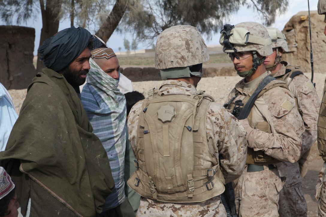 U.S. Navy Hospital Medic Robert De Les Santos, a corpsmen with Company L, Battalion Landing Team 3/8, 26th Marine Expeditionary Unit, Regimental Combat Team 8, listens to an interpreter during a patrol to provide assistance to Afghan nationals in Amanollah Kariz, Helmand province, Afghanistan, Feb. 13, 2011. Elements of the 26th Marine Expeditionary Unit deployed to Afghanistan to provide regional security in Helmand province in support of the International Security Assistance Force.