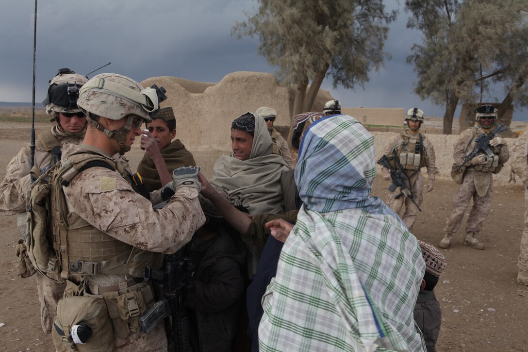 U.S. Marine Corps Sgt. Robert J. Blumenberg, a squad leader with 3rd Platoon, Company L, Battalion Landing Team 3/8, 26th Marine Expeditionary Unit, Regimental Combat Team 8, passes out sticks of gum to children in the village of Amanollah Kariz, Helmand province, Afghanistan, Feb. 13, 2011. Elements of the 26th Marine Expeditionary Unit deployed to Afghanistan to provide regional security in Helmand province in support of the International Security Assistance Force.