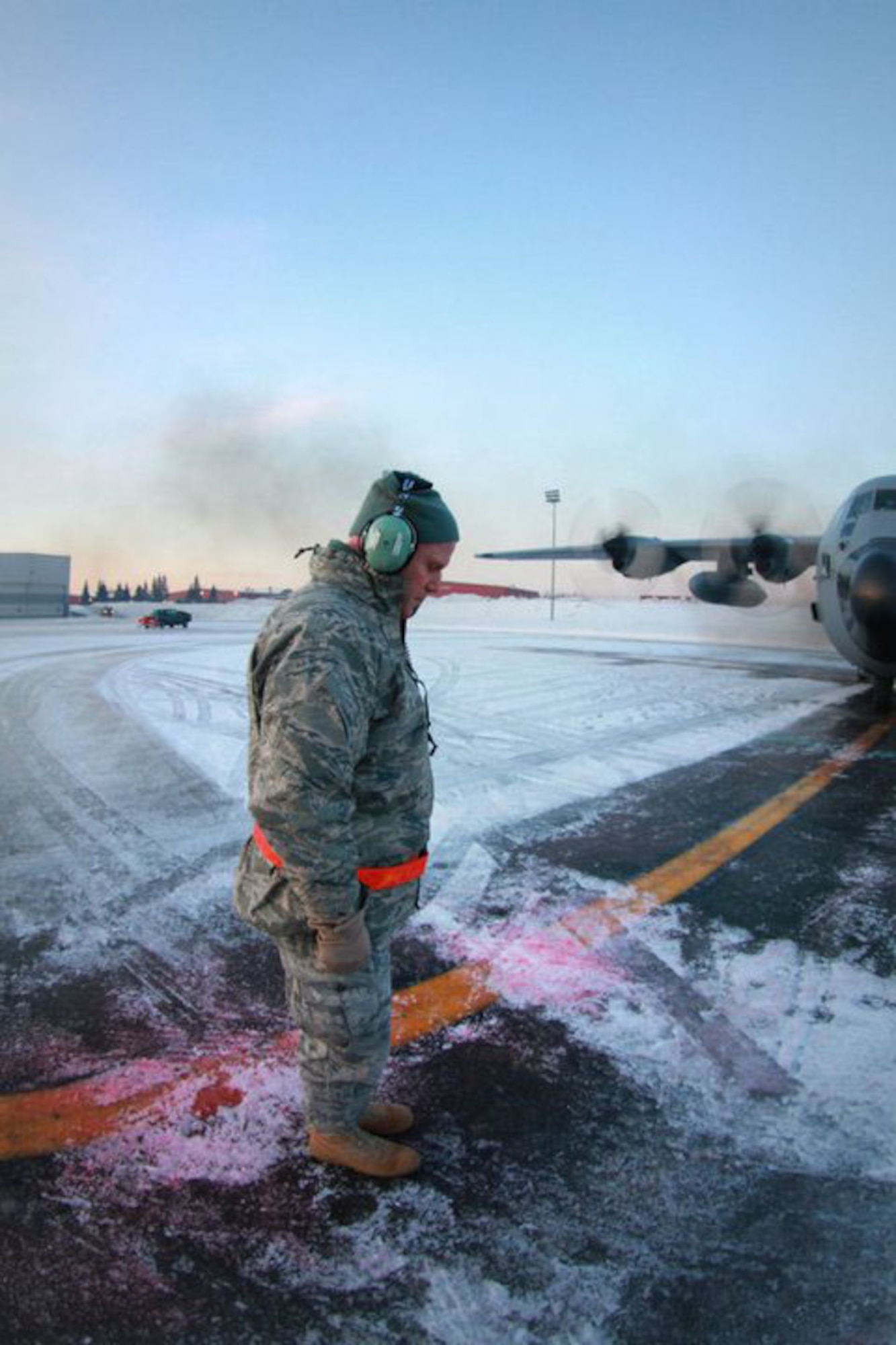 KULIS AIR NATIONAL GUARD BASE, Alaska - Maj. Matthew Friese, a chaplain with the 176th Wing, blesses a C-130 before a flight, Feb. 12, 2011. The C-130 along with 10 other aircraft from the 176th Wing was flown from Kulis to Joint Base Elmendorf-Richardson during a ceremonial flight. The Wing is relocating from Kulis to JBER per the 2005 Defense Base Closure and Realignment proposal.  Alaska Air National Guard photo by Tech. Sgt. Julie Arthur.