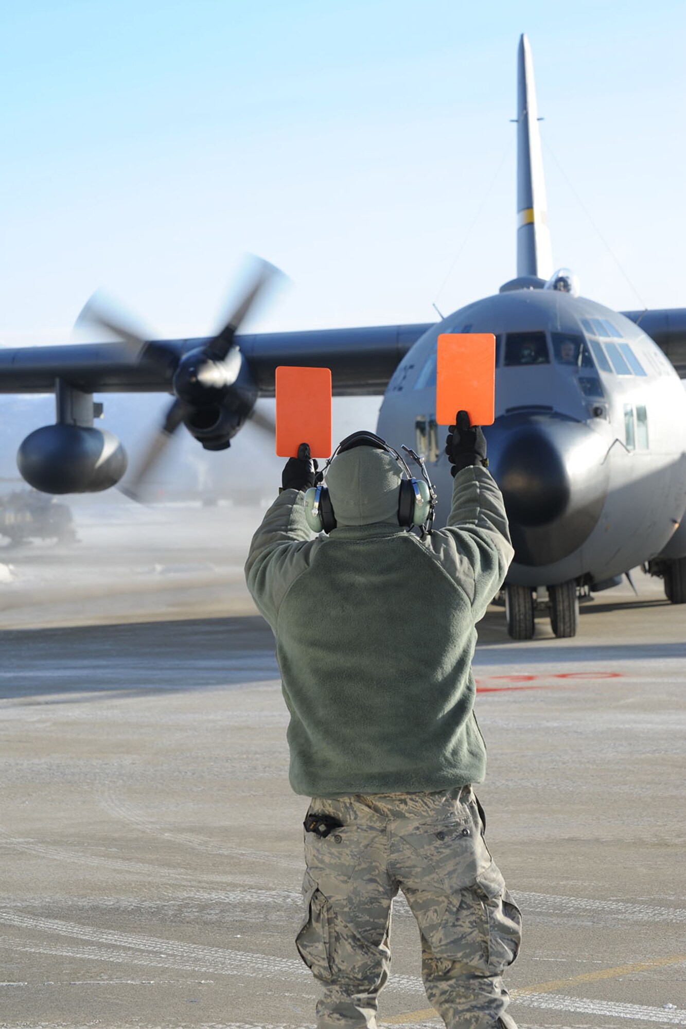 JOINT BASE ELMENDORF-RICHARDSON, Alaska - Senior Airman Alexander Van Nice, a crew chief with the 176th Aircraft Maintenance Squadron, marshals in a C-130 from the 144th Airlift Squadron, Feb. 12, 2011. The aircraft was flown from Kulis to Joint Base Elmendorf-Richardson during a ceremonial flight. The 176th Wing is relocating from Kulis to JBER per the 2005 Defense Base Closure and Realignment proposal.  Alaska Air National Guard photo by Master Sgt. Shannon Oleson.