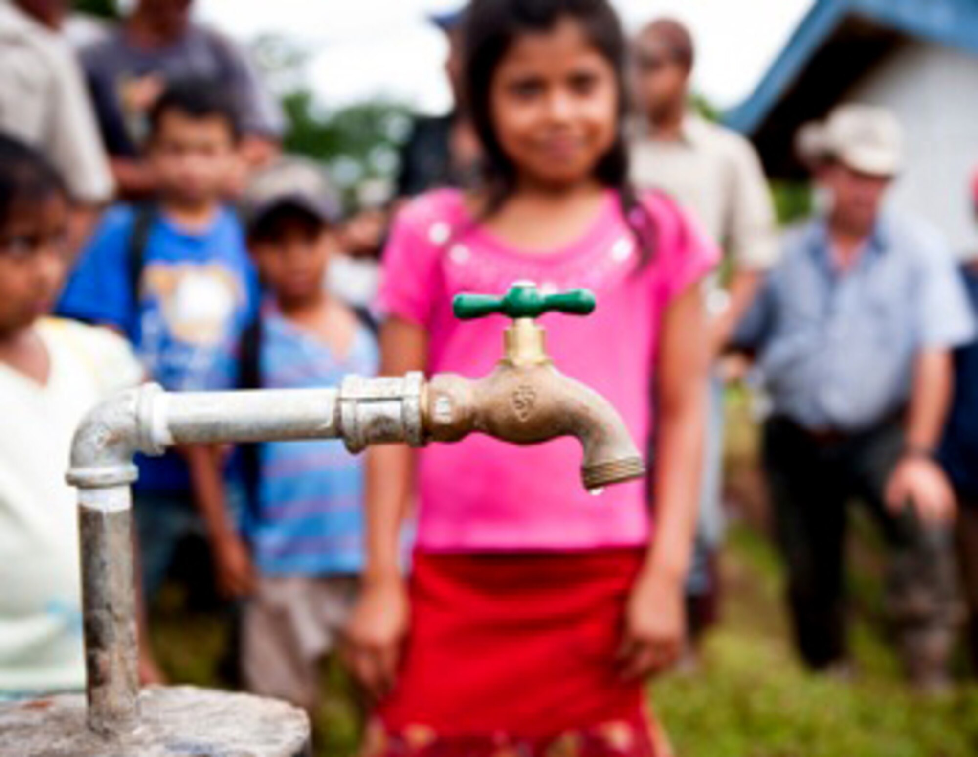 NICARAGUA, South America- A standpipe glistens in the foreground as a community of Nicaraguans observe their new source of clean drinking water, provided to them by two non governmental organizations. Staff Sgt. Jon Polka, 728 Airlift Squadron, Joint Base Lewis-McChord, McChord Field, Wash., spent three weeks as a volunteer photographer for Blue Planet Network, a NGO funding organization that  assists relief efforts that address the global water crisis. (Courtesy Photo/Staff Sgt. Jon Polka)