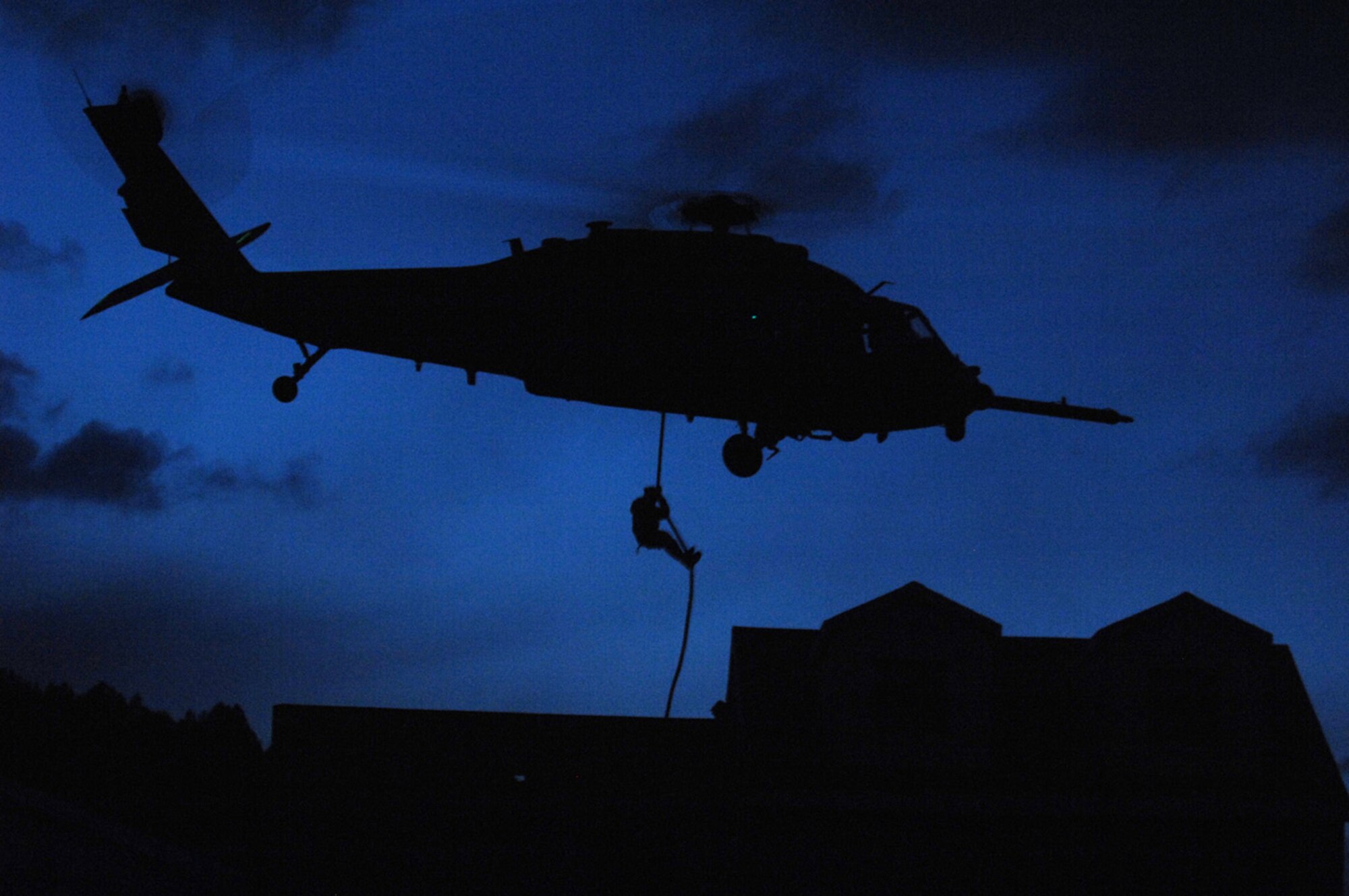 A member of the 19th Special Forces Group, Utah Army National Guard, fast ropes from a U.S. Air Force (USAF) HH-60 Pave Hawk helicopter into an urban village at night during the Utah Combat Search and Rescue Joint Integration Exercise 2008 at Camp Williams, Utah, May 10, 2008. The 34th Weapons Squadron, USAF Weapons School based at Nellis Air Force Base, Nev., led the search and recovery training. (U.S. Air Force photo by Master Sgt. Kevin J. Gruenwald/Released)